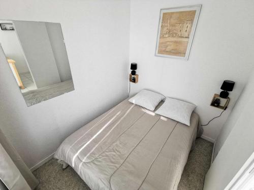 une petite chambre avec un lit et un miroir dans l'établissement Résidence Les Terrasses Du Port - 2 Pièces 4 couchages PORT LEUCATE MAE-5514, à Port-Leucate