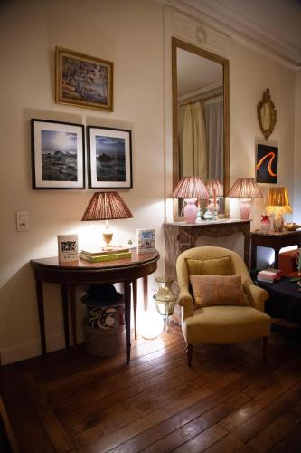 un salon avec une table, une chaise et un miroir dans l'établissement Arc de Triomphe Chic Room, à Paris