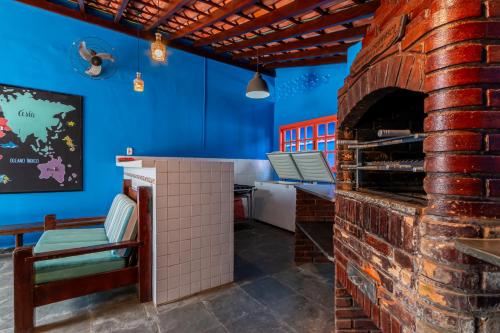 um forno de tijolo num restaurante com paredes azuis em Positano Ilhabela Lodges em Ilhabela