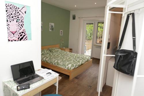 a bedroom with a bed and a desk with a laptop at Vatican Garden Oasi in Rome