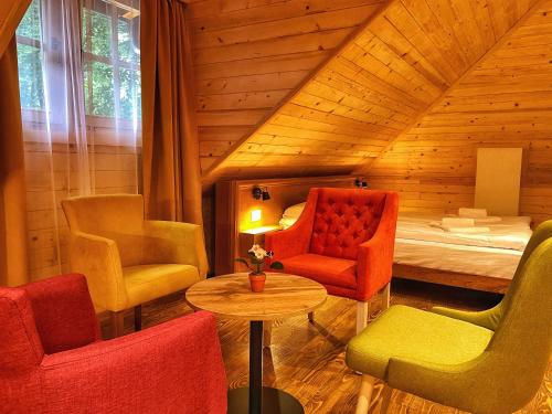 Zimmer mit Stühlen und einem Bett im Dachgeschoss in der Unterkunft Hotel Porto Tara in Žabljak