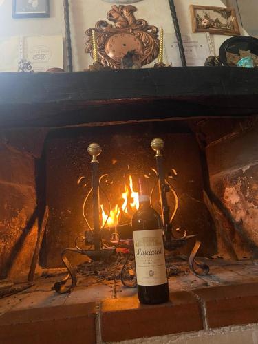 - Botella de vino frente a la chimenea en Da Nonna Gina, en Pescasseroli