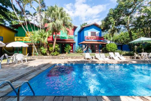 uma piscina em frente a uma casa com um resort em Positano Ilhabela Lodges em Ilhabela