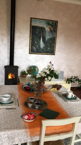 a table with a vase of flowers and a fireplace at La mimosa in San Mauro Pascoli
