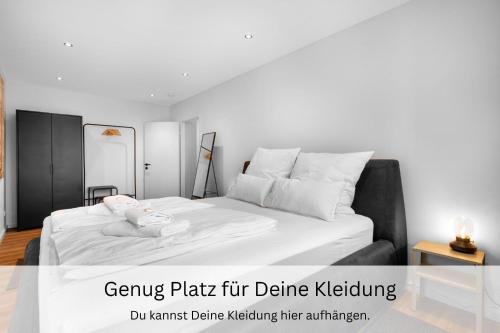 a bedroom with a white bed with a stuffed animal on it at Urban Jungle Industríal Parkplatz Balkon Business in Dreieich