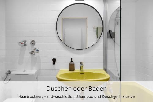 uma casa de banho com um lavatório amarelo e um espelho. em Business Frankfurt Family FreeParking Netflix Wifi em Dreieich