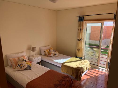 2 Betten in einem Zimmer mit Fenster in der Unterkunft HSH Gomeira Cabanas Beach in Cabanas de Tavira