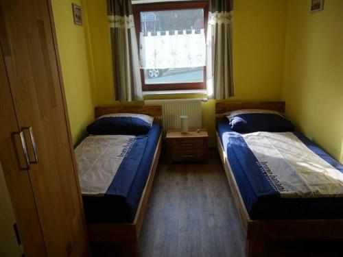- 2 lits dans une petite chambre avec fenêtre dans l'établissement Holiday apartment Brandl Haus 92, à Arrach