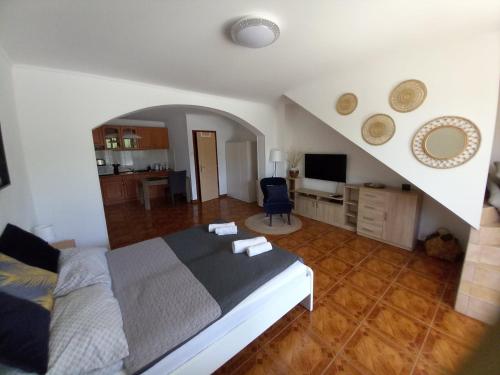a bedroom with a large bed and a kitchen at Green Garden Apartments in Siófok