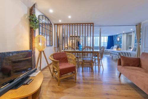 un salon avec un canapé, une table et des chaises dans l'établissement La Chambrée des Chalands, à Blois