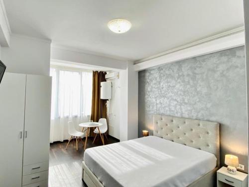 1 dormitorio con 1 cama grande y 1 mesa en ApartHotel Near the Sea, en Mamaia Nord – Năvodari