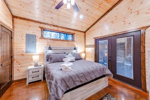 a bedroom with a bed in a wooden cabin at The Luxurious Blue Sky Lodge is EPIC! in Broken Bow