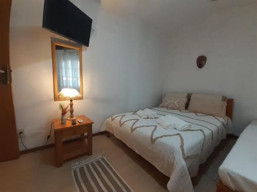 a bedroom with a bed and a table and a television at Aldeia Maravista in Niterói