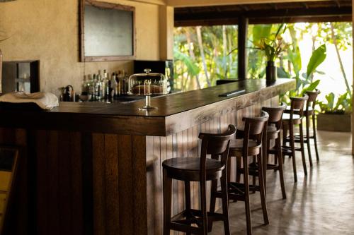 un bar con una fila de taburetes en un restaurante en OMIA en Tangalle