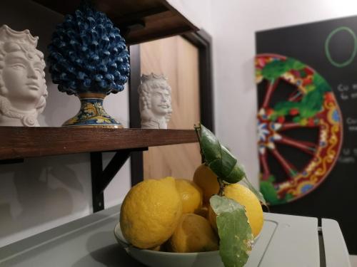 una ciotola di limoni su un tavolo con un cactus di Ovidio home a Palermo