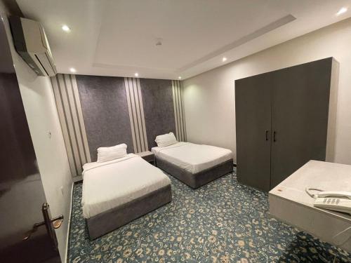 Habitación de hotel con 2 camas y TV en اجواء المساء للوحدات السكنيه المفروشه, en Riad