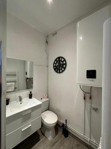 une salle de bain blanche avec des toilettes et un lavabo dans l'établissement Le voyage à Dieppe au centre ville, à Dieppe