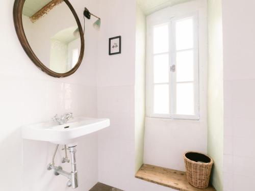 ein Bad mit einem Waschbecken und einem Wandspiegel in der Unterkunft Casa Aquadulza in Tremezzo