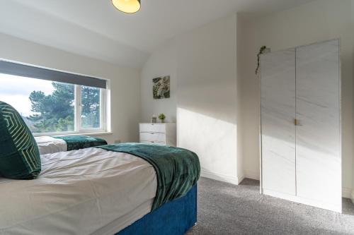 a bedroom with two beds and a window at New 4BR family home sleeps 8 -10 people with free parking and contractors welcome in Birmingham