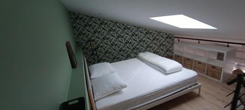 un lit avec deux oreillers dessus dans une chambre dans l'établissement Le Colibri, à Saint-Jean-de-Monts