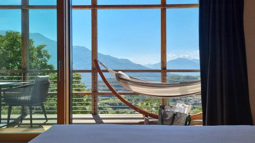 a room with a bed and a large window with a hammock at ARPA DI PIETRA - Luxury B&B SPA BIO - Adults Only in Mori