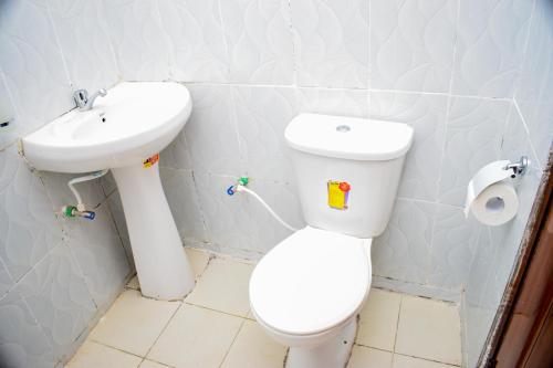 a bathroom with a white toilet and a sink at ndush home in Rutara