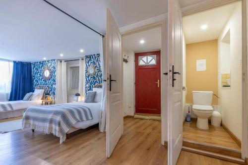 1 dormitorio con 1 cama y puerta roja en La Maison des Chalands, en Blois