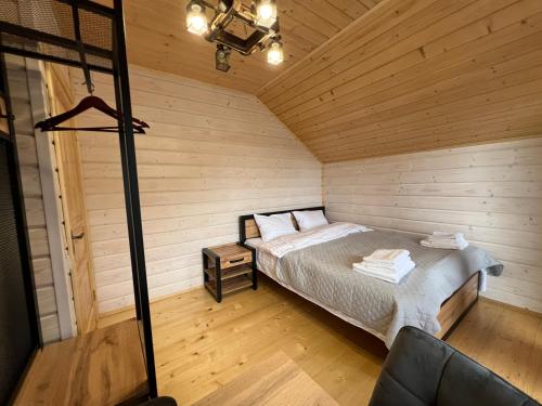 a bedroom with a bed in a wooden cabin at Kolos house in Slavske
