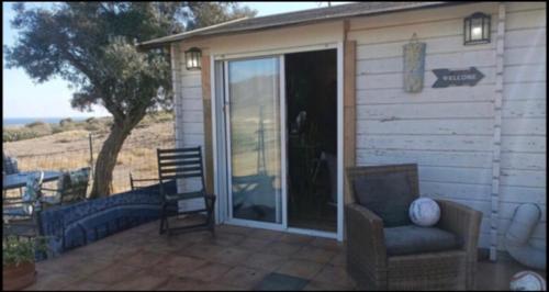a patio with a chair and a sliding glass door at Alojamiento PlayaArco in Los Escullos