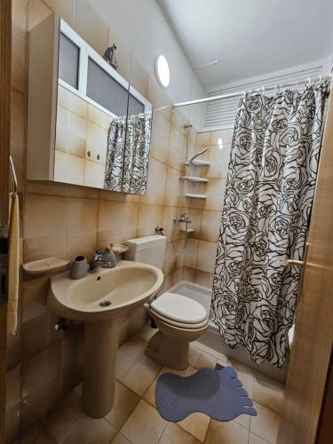e bagno con lavandino, servizi igienici e doccia. di Apartments Rusin a Krk