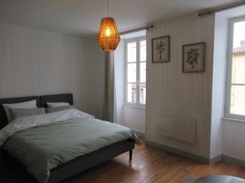 a bedroom with a bed and a chandelier at Appartement village in Simorre