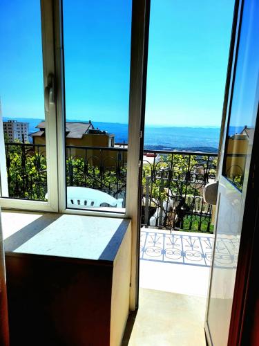 a room with a view of the ocean from a balcony at Garden Villa Guni in Krujë