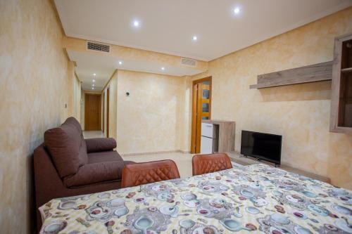 a bedroom with a bed and a couch and a television at Apartamento 1 Calle Tierno Galvan in Cox