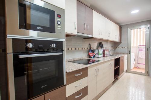a kitchen with a sink and a microwave at Apartamento 1 Calle Tierno Galvan in Cox