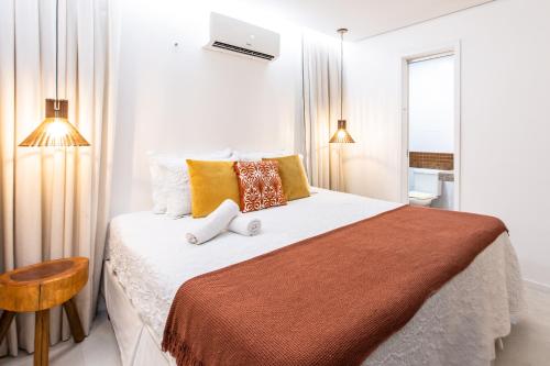 a bedroom with a large bed with yellow and orange pillows at Casa La Baule in Aquiraz