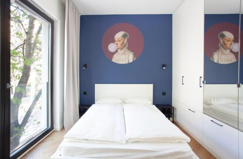 sypialnia z białym łóżkiem i niebieską ścianą w obiekcie ElegApart w mieście Gdynia
