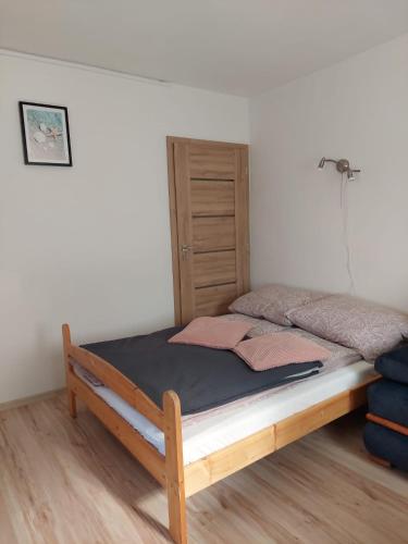 a bed with a wooden frame in a room at Apartament Muszelka in Puck