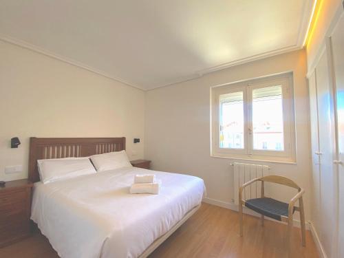 a bedroom with a bed and a chair and a window at Apartamento en la Catedral in Burgos