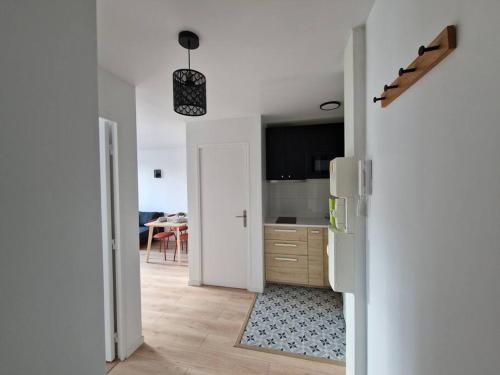 une cuisine avec un réfrigérateur blanc et une table dans l'établissement WD Saint Roch - Appartement 201 - Métro 7 Proche Paris, à Villejuif