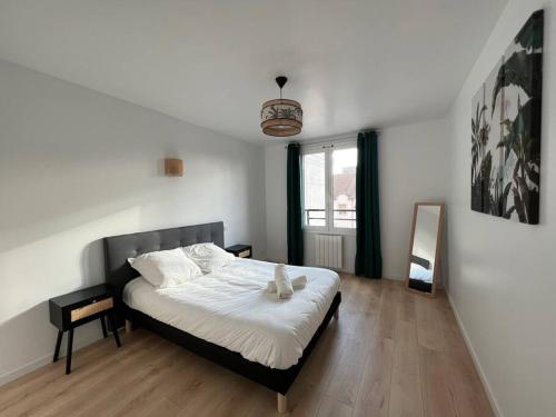 - une chambre avec un lit et un miroir dans l'établissement WD Saint Roch - Appartement 201 - Métro 7 Proche Paris, à Villejuif