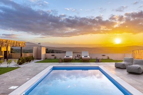 a villa with a swimming pool and a sunset at Iliovasilema Luxury Apartment in Heraklio Town