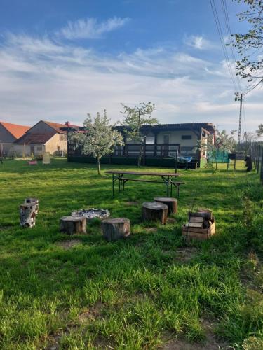 a park with a picnic table and logs in the grass at Siedlisko Kalimera in Orzysz