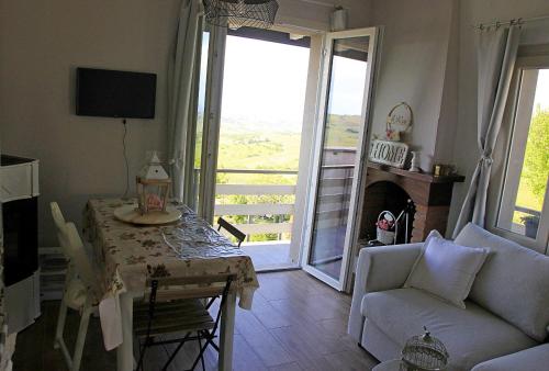 een woonkamer met een tafel en een bank bij NiFe Tiny House - Secret Garden in Montalbo