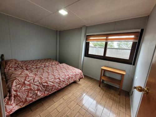 a small bedroom with a bed and a window at Hospedaje Alimar in Frutillar