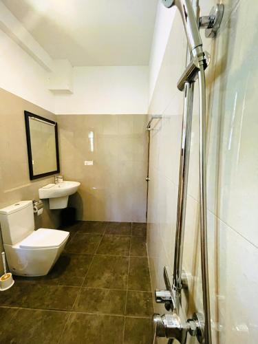 een badkamer met een toilet en een wastafel bij New Cinnoman Villa in Bentota