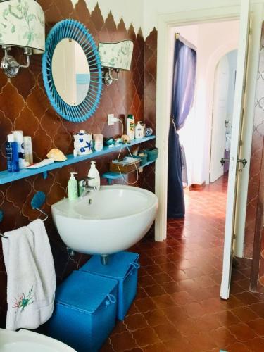 a bathroom with a white sink and a mirror at Villa Rachele in Procida