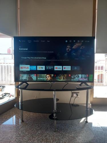 a large flat screen tv sitting on a stand at Bluesky Apartment Naxos 3rd floor in Giardini Naxos
