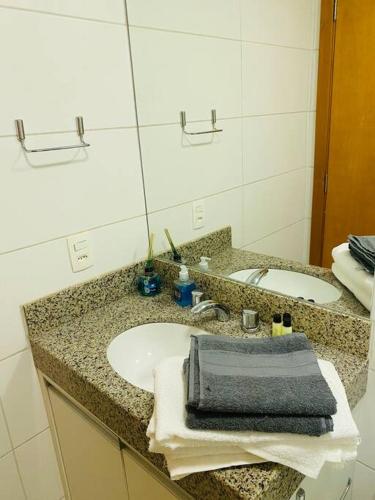 a bathroom counter with a sink and a mirror at Lazer e shopping Apt DF Plaza in Brasília