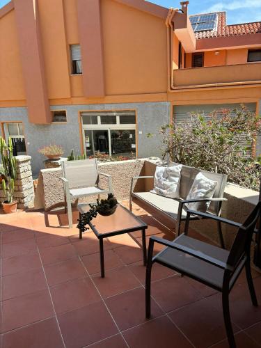 a patio with chairs and a table and a building at Casa Fiorella - Vista Mare in Palau