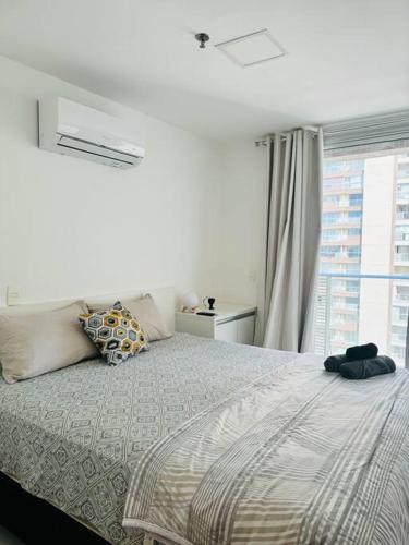 a white bedroom with a bed with a window at Lazer e shopping Apt DF Plaza in Brasília